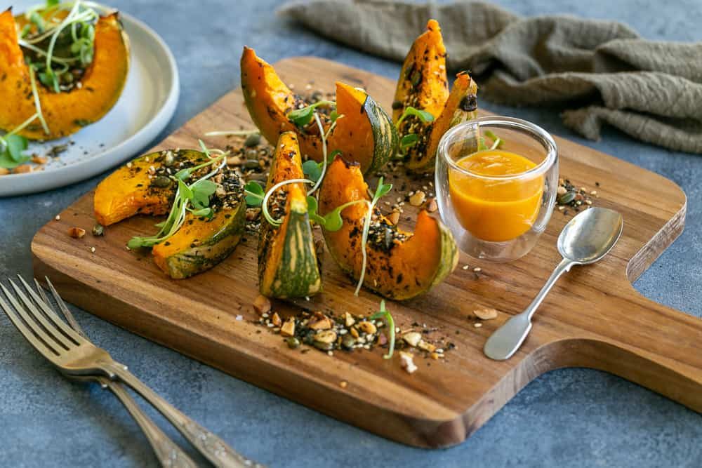 Roasted Pumpkin with Miso and Nori Nut Dukkah on a wooden board served as a sharing platter